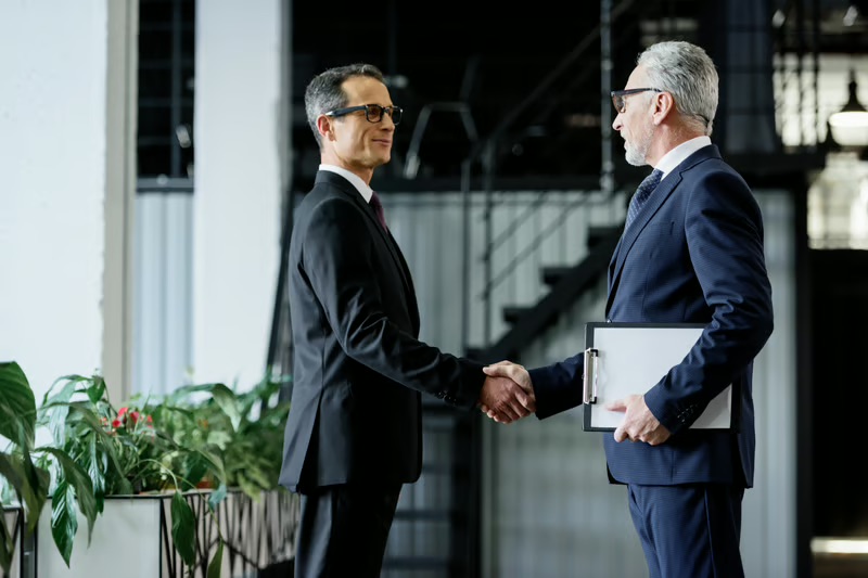 Family office investors shaking hands after discussing a private market investment opportunity.