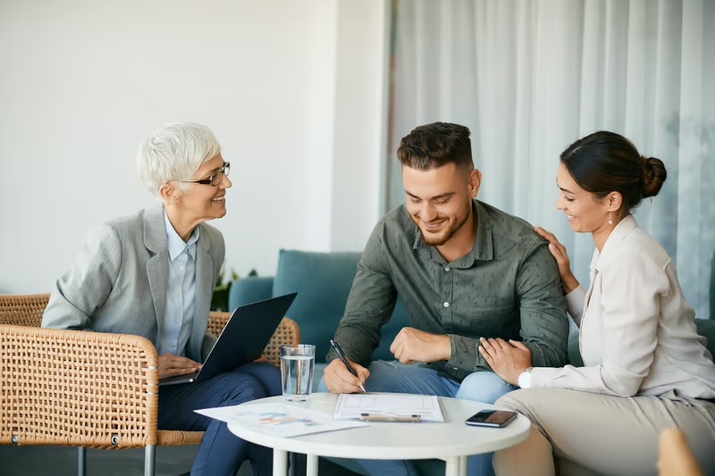 Family members and a wealth advisor reviewing financial data during a family office investment meeting.